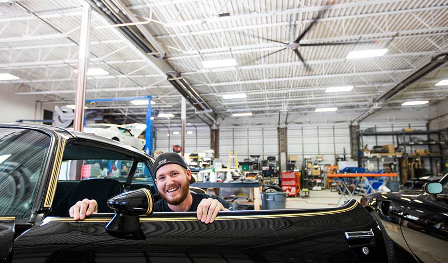 Mechanic in shop under HVLS fan.