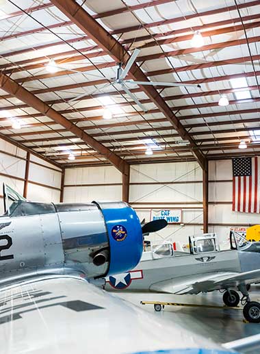 Large diameter ceiling fan in aircraft hangar.